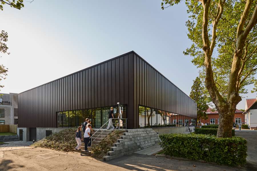 New sports hall in the “forest” wrapped in acorn-brown steel profiles, Risskov Efterskole, Tretommervej 31A, 8240 Risskov, Denmark